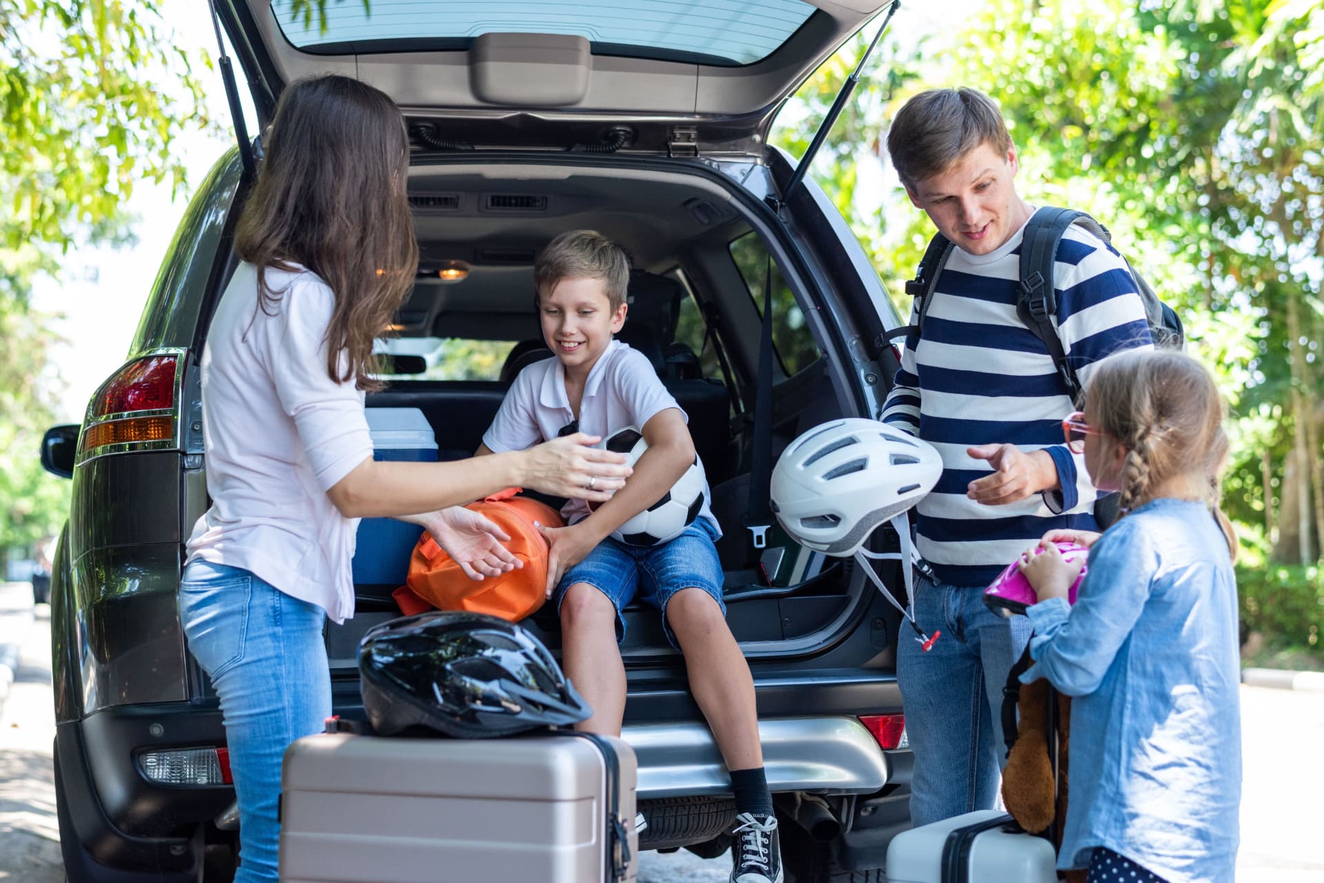 Família carregando o porta-malas do carro para uma viagem